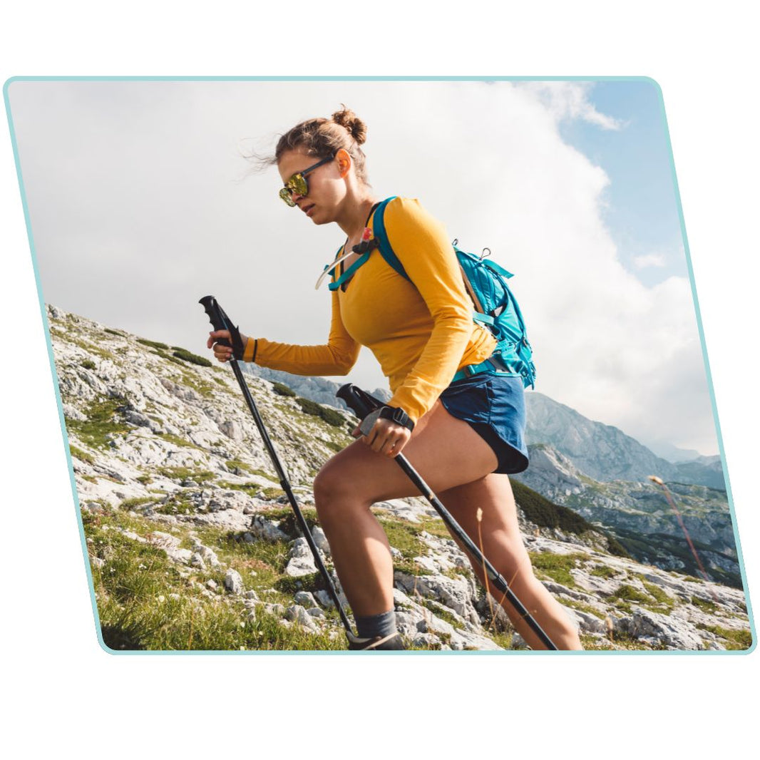 Woman hiking on a mountain with a backpack and poles